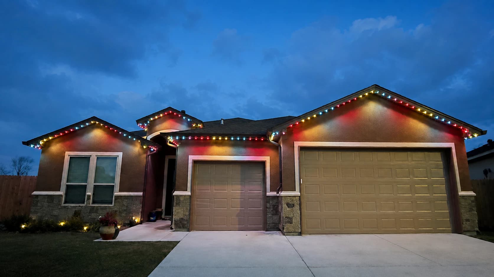 Customer-supplied LIT365 installation: a home's facade with every gable illuminated in red and warm-white permanent lighting at night