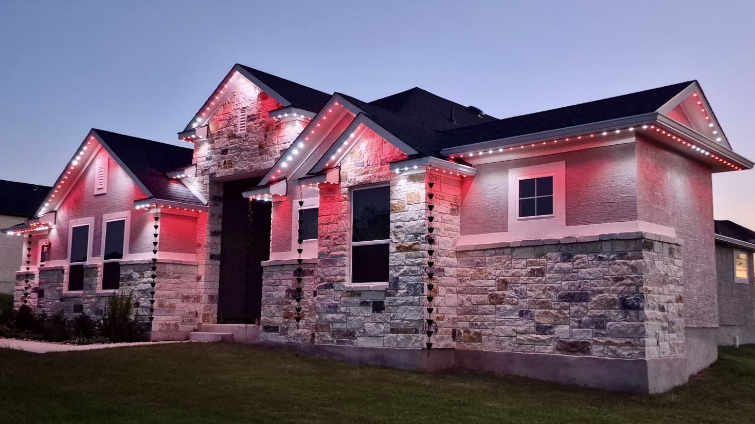 Customer-supplied LIT365 installation: a home's facade and roofline in a red permanent-lighting scene at night