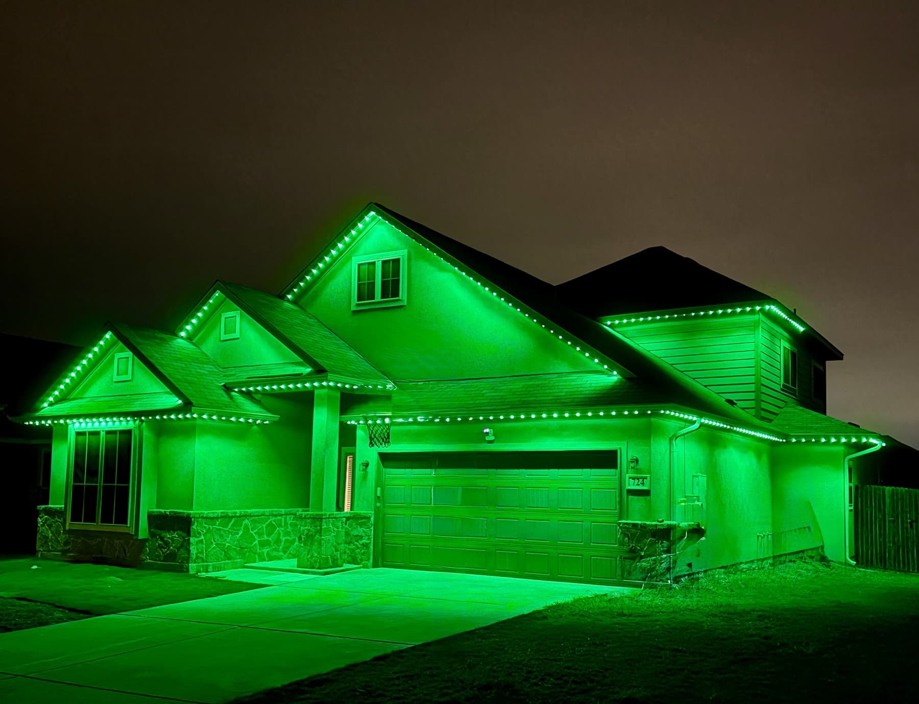 Customer-supplied LIT365 installation: a full house with its complete roofline lit in a green permanent-lighting scene